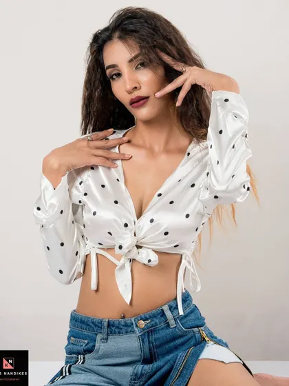 A close-up portrait from the 'Polka Dots' shoot. The model's pose and direct gaze highlight the stylish satin top and her modern, fashion-forward vibe.