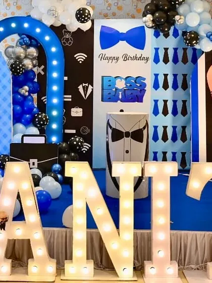A close-up of a Boss Baby themed birthday party, highlighting the character cutouts and themed backdrops with tie patterns.