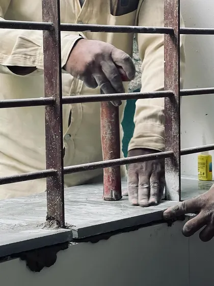 A collection of images and videos documenting various stages of construction, from site visits and foundation work to the detailed installation of architectural fittings and finishes.