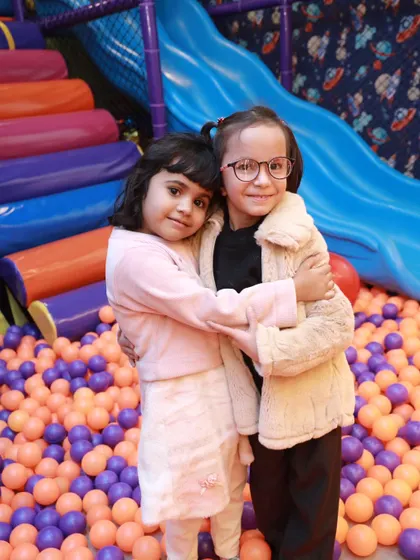 Making new friends is part of the fun. Here, two friends share a hug in our colorful ball pit, a perfect example of the happy social interactions we love to see.