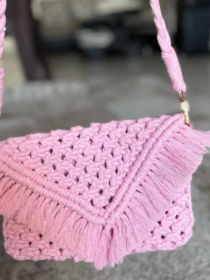 This baby pink macrame sling bag is so sweet. It has a delicate fringe and a sturdy, braided strap that you can detach if you want to use it as a clutch.