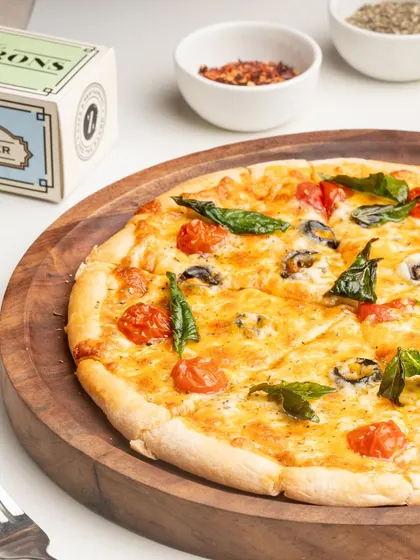 My Margherita pizza is a testament to classic simplicity. It's made with a rich tomato sauce, fresh mozzarella, cherry tomatoes, and basil.