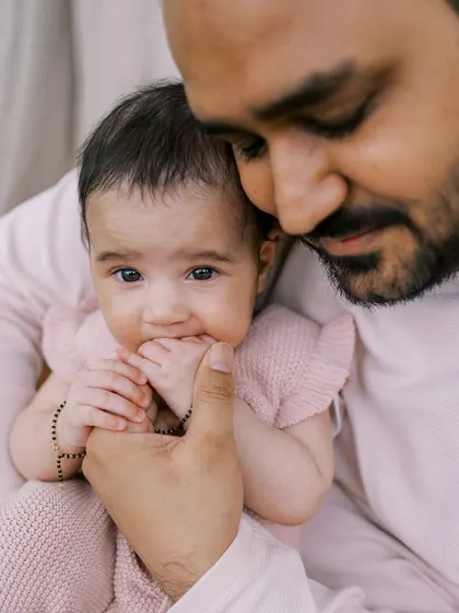 A father holding his three-month-old daughter. It's amazing to see how much they change in just a few months.