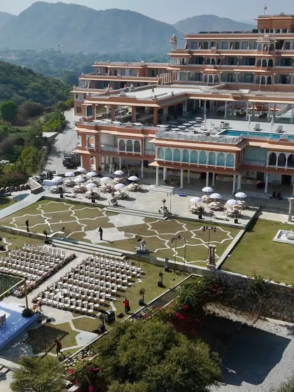 A wide shot showcasing the scale of this destination wedding in Udaipur. The mandap was positioned to take full advantage of the palace architecture and the infinity pool, creating a truly royal wedding experience.