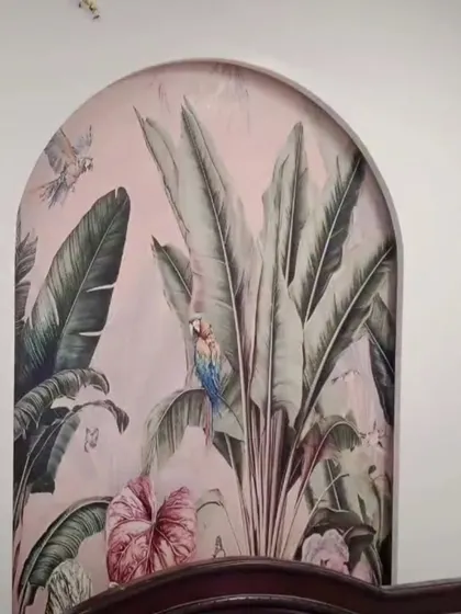 A tropical mural with parrots and lush foliage inside an arch above a bed, creating a cozy and exotic headboard feature.