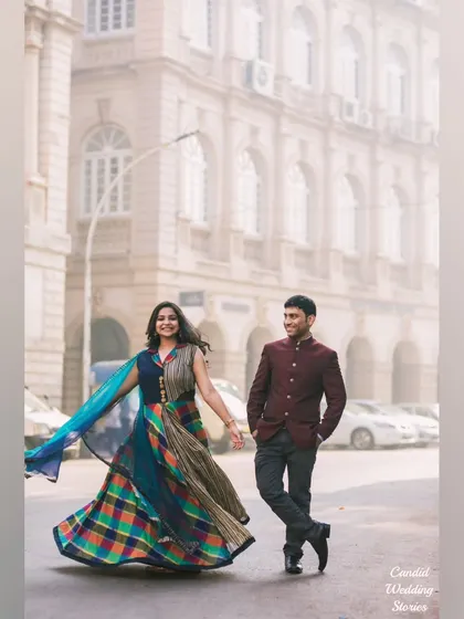 A beautiful shot of the bride-to-be twirling in a colourful lehenga on a misty Mumbai street, creating a sense of movement and joy.