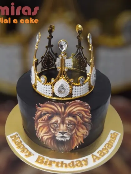 A powerful and regal cake for a birthday king. This black cake features a majestic lion's portrait and is topped with an ornate white and gold crown.