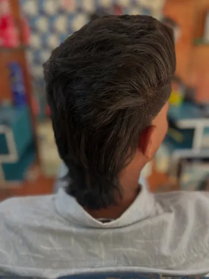A view from the back, showing exactly how the mullet haircut is shaped. The length is concentrated at the nape of the neck for that signature look.