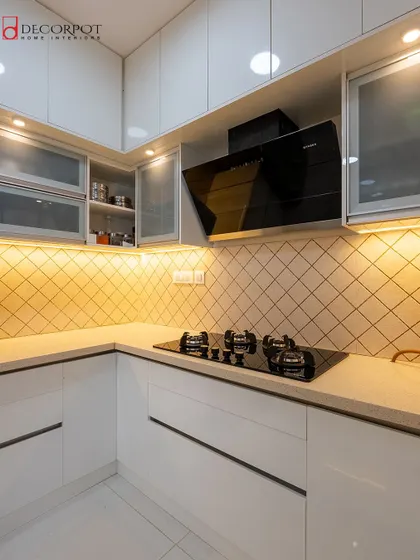 This all-white L-shaped kitchen is the definition of clean and modern. The diamond-patterned tile backsplash adds a subtle texture, while the under-cabinet lighting provides a warm, inviting glow.