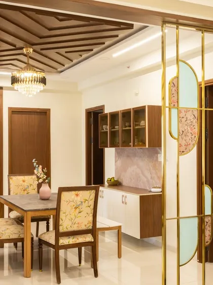 A sleek partition in this Hyderabad home separates the living and dining areas. The design incorporates geometric patterns with frosted glass for privacy and style.