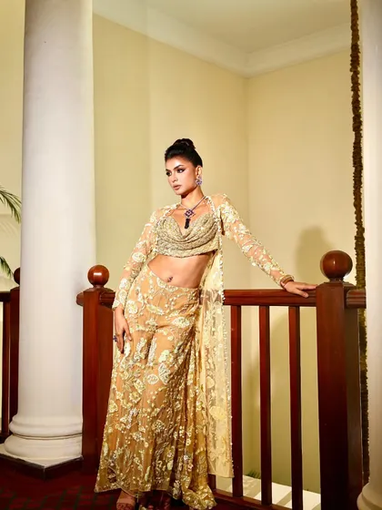 A full-length shot of the golden pantsuit, a chic and modern choice for a pre-wedding event.