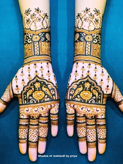 Symmetrical full-hand designs with a mix of floral and peacock motifs. The use of dark and light shading creates a beautiful contrast.