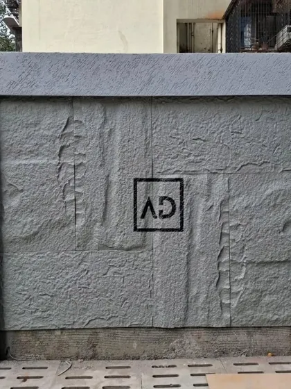 A finished exterior wall section featuring grey PU stone cladding. This is a great way to add texture and a modern, rugged look to compound walls or building exteriors.