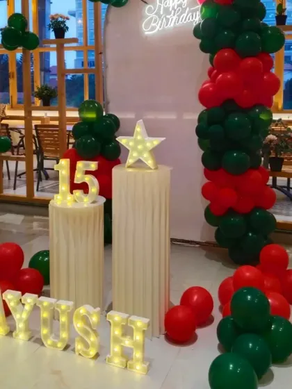 The full view of the 15th birthday decor, with the name 'Ayush' spelled out in marquee letters on the floor.