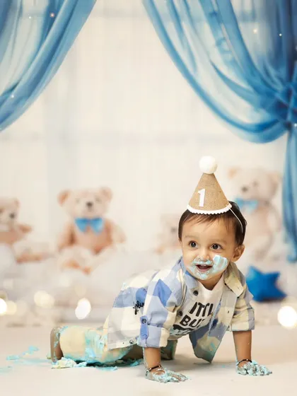 Even with cake on his face, he's on the move! This crawling shot shows his playful energy during the cake smash. We love capturing these action shots that show your baby's personality.