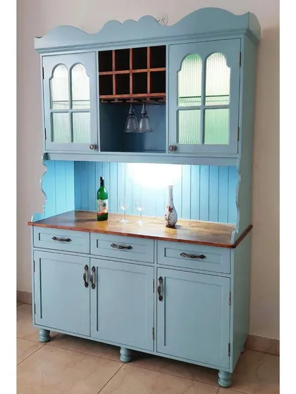 A charming hutch cabinet painted in a lovely powder blue. It features a wine rack, glass holders, and ample storage, bringing a touch of vintage farmhouse style to the home.