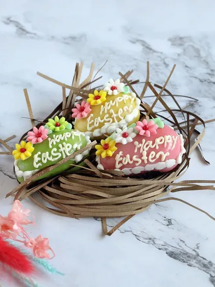 These colorful Easter egg chocolates are hand-decorated with "Happy Easter" greetings and floral designs, making them a beautiful and personal gift.