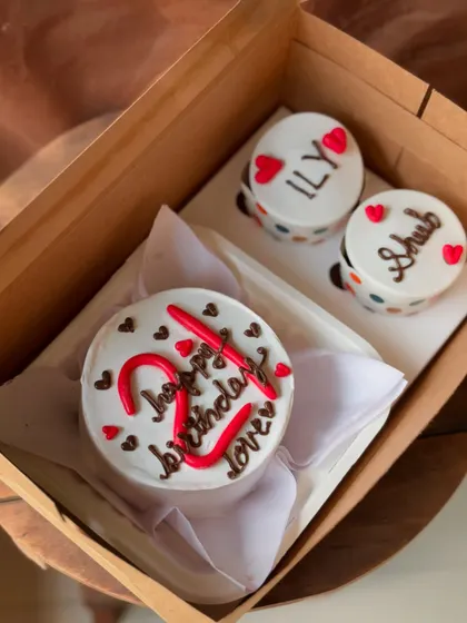 A sweet and romantic combo for a 21st birthday. The bento cake is decorated with red lettering and hearts, and the two cupcakes have personalized messages "ILY" and "Shub."