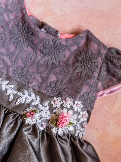 A unique design featuring a grey satin skirt paired with a lavender and grey lace bodice. The waist is adorned with delicate white and pink ribbon flowers, showcasing my love for handcrafted details.
