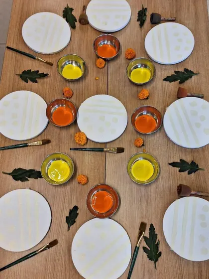 This art invitation is prepared with symmetry and beauty in mind. Circular canvases, bowls of paint, and natural elements are arranged to be aesthetically pleasing, communicating to the child that their work and materials are valued.