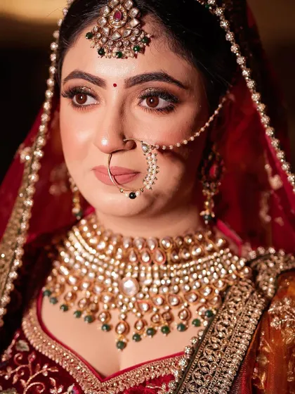 A close-up of the bride's face, highlighting her beautiful nath and heavy choker.
