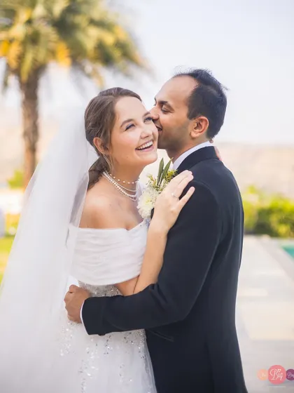 A joyful, candid kiss. Nelya and Tirath's happiness is contagious after their beautiful white wedding.