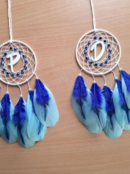 A pair of personalized initial car hangings, 'P' and 'D', featuring our popular evil eye design with blue feathers. A great gift for couples or friends.