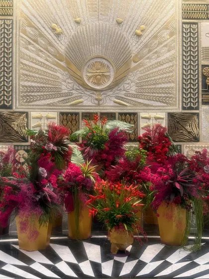The checkerboard floor and gilded wall are the perfect dramatic backdrop for these lush, jewel-toned floral arrangements.