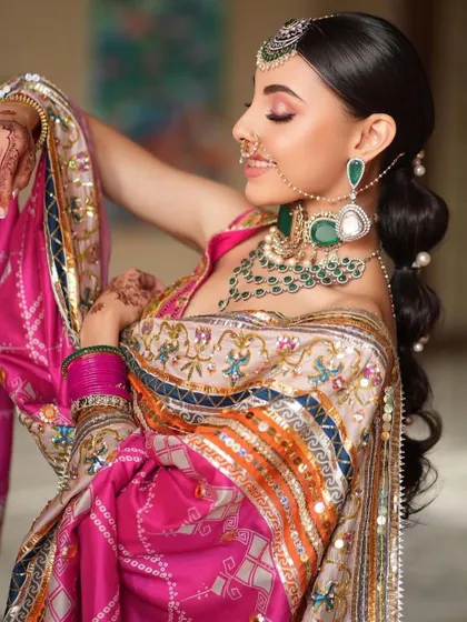 A joyful and candid shot of a bride in a colorful phulkari-inspired outfit. I teach how to create makeup that allows for expression and movement, ensuring your client feels comfortable and beautiful.