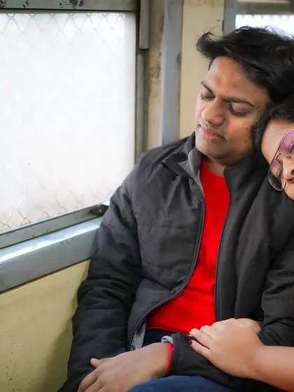 A peaceful moment of rest on a journey together. This image captures a sense of comfort and trust, telling a story of finding home in one another, even on a bustling Mumbai local train.