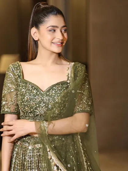A happy and radiant portrait in our olive green lehenga. This outfit is sure to make any wedding guest feel beautiful and confident.