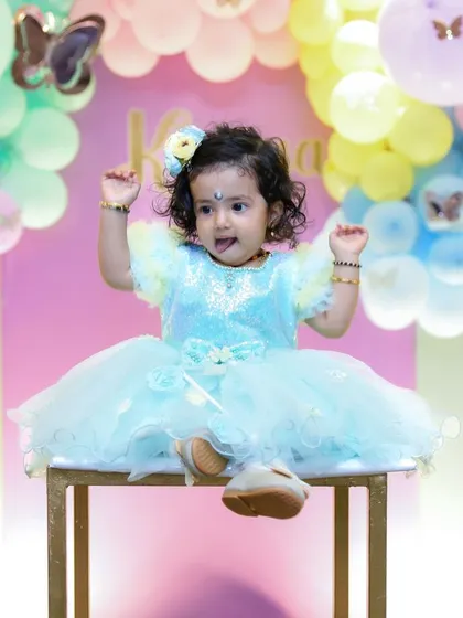 This little one is striking a pose. We love her playful energy, captured perfectly in our bright and colorful studio.
