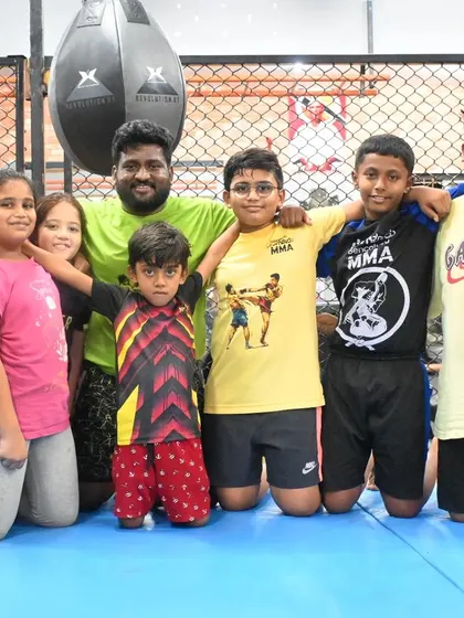 Our kids' class posing with their coach. Enroll your kids with us and let them begin their journey of self-discovery and empowerment.