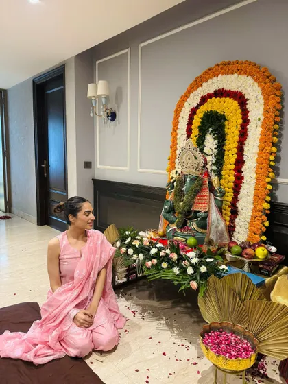A moment of prayer during Ganpati celebrations, wearing a simple and elegant pink suit.