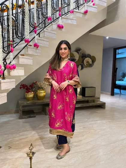 A happy, full-length shot of my Diwali outfit. The stairs are decorated with flowers, adding to the festive atmosphere.