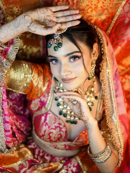 An overhead shot that provides a unique perspective on the bridal makeup and henna-adorned hands.