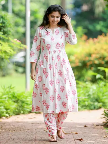 Comfort and style in perfect harmony. This white and pink printed kurta pant set is ideal for every festive moment.