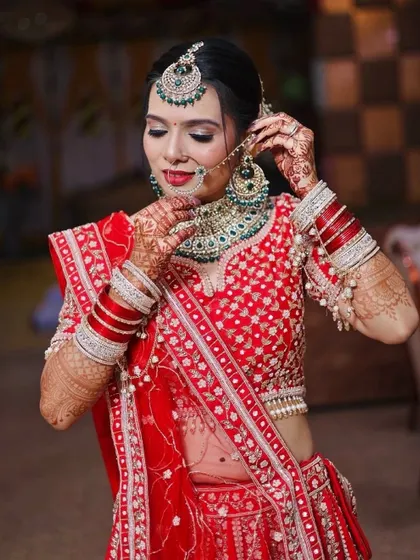 Adjusting the jewelry is part of the process. The makeup is set to be transfer-proof, even around heavy necklaces and earrings.