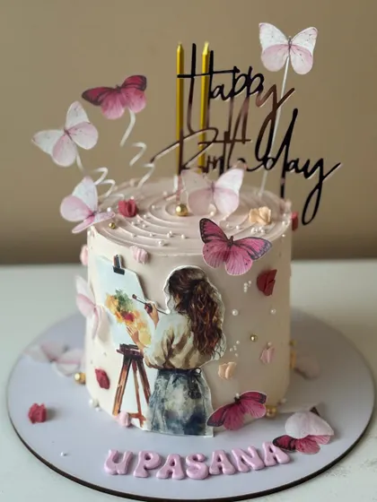A cake for the artist, featuring a painter at her easel, surrounded by delicate edible butterflies.