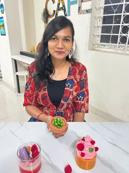A guest with her unique set of candles, including a cupcake, a succulent pot, and a layered dessert glass.