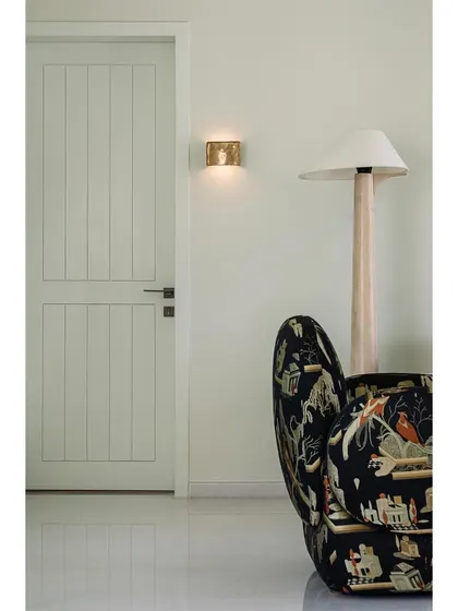 A detail of the family lounge, showing a statement armchair with a whimsical pattern next to a simple, elegant door.