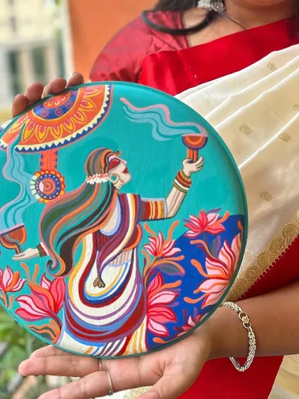 A close-up of one of the Pujo plates, depicting a woman performing the 'dhunuchi' dance.