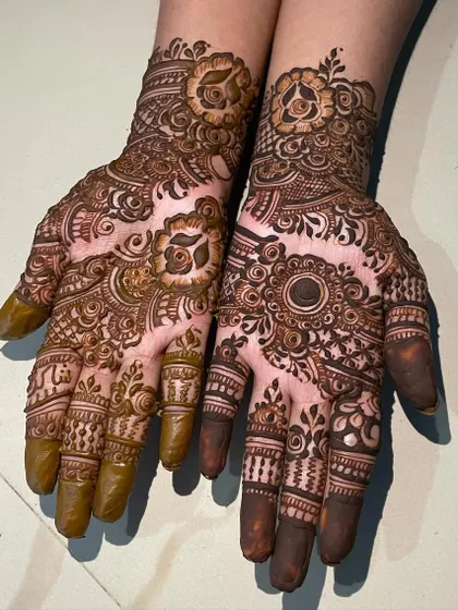 A beautiful example of mixed-style henna, with one hand featuring a floral design and the other a bold mandala. This is great for clients who want variety.