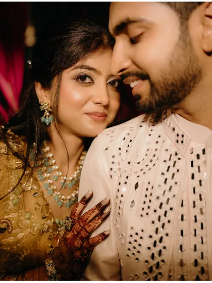 A warm, intimate close-up of the couple. The bride's gentle touch and their soft smiles create a feeling of comfort and deep affection.