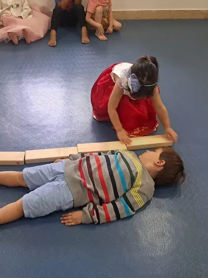 How tall am I? Our pre-kindergarteners use wooden blocks as a non-standard measuring tool to measure their friends, learning about length and counting in a tangible way.