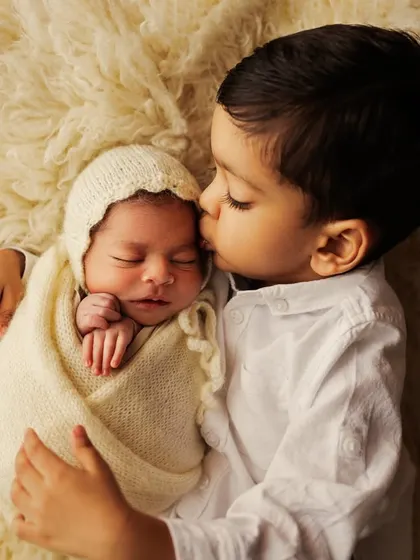 A tender kiss for the new baby from their big brother. A precious moment of sibling love captured during a newborn session.
