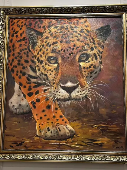 This realistic oil painting of a leopard is a throwback to our "Roar of Art" exhibition. The intense gaze and detailed fur make this a captivating piece of wildlife art, presented in an ornate gold frame.