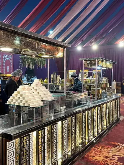 This dessert station features pyramids of traditional Indian sweets like sandesh, set up on a modern, illuminated counter. It's a perfect blend of classic taste and contemporary presentation.