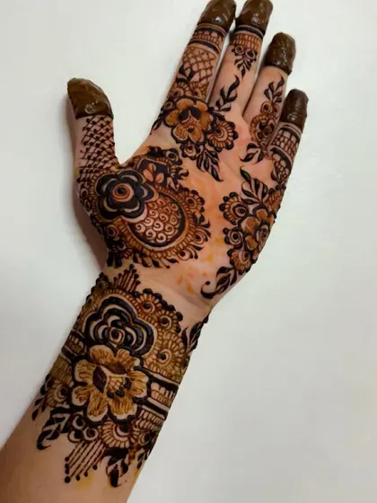 A close-up of a single hand adorned with a beautiful floral and paisley cuff design. This shows the detail and precision I put into every element, from the main pattern to the finger details.