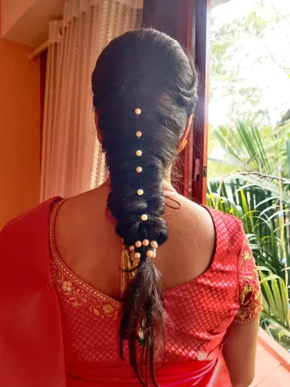 A simple yet elegant braided hairstyle. This look uses pearls spaced down the length of the braid, offering a clean and sophisticated alternative to more elaborate floral arrangements.